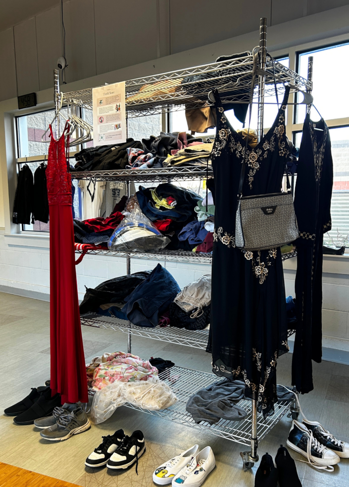 Clothing display featuring casual and formal wear, including dresses and footwear, in a bright setting.